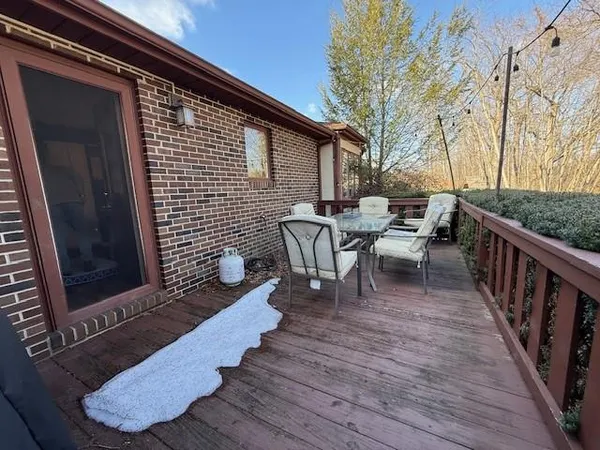 a view of a patio with table and chairs with wooden floor and fence