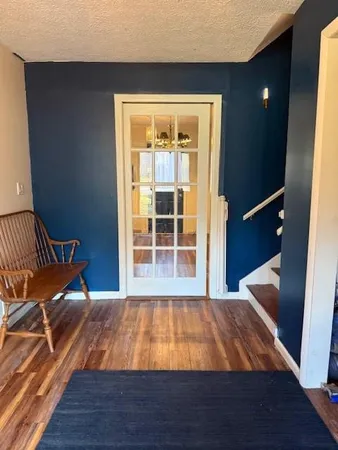 a room with a bed and wooden floor