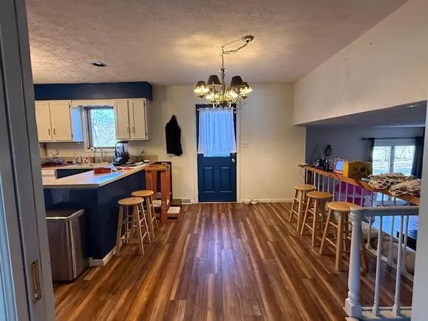 a room with wooden floor table and chairs