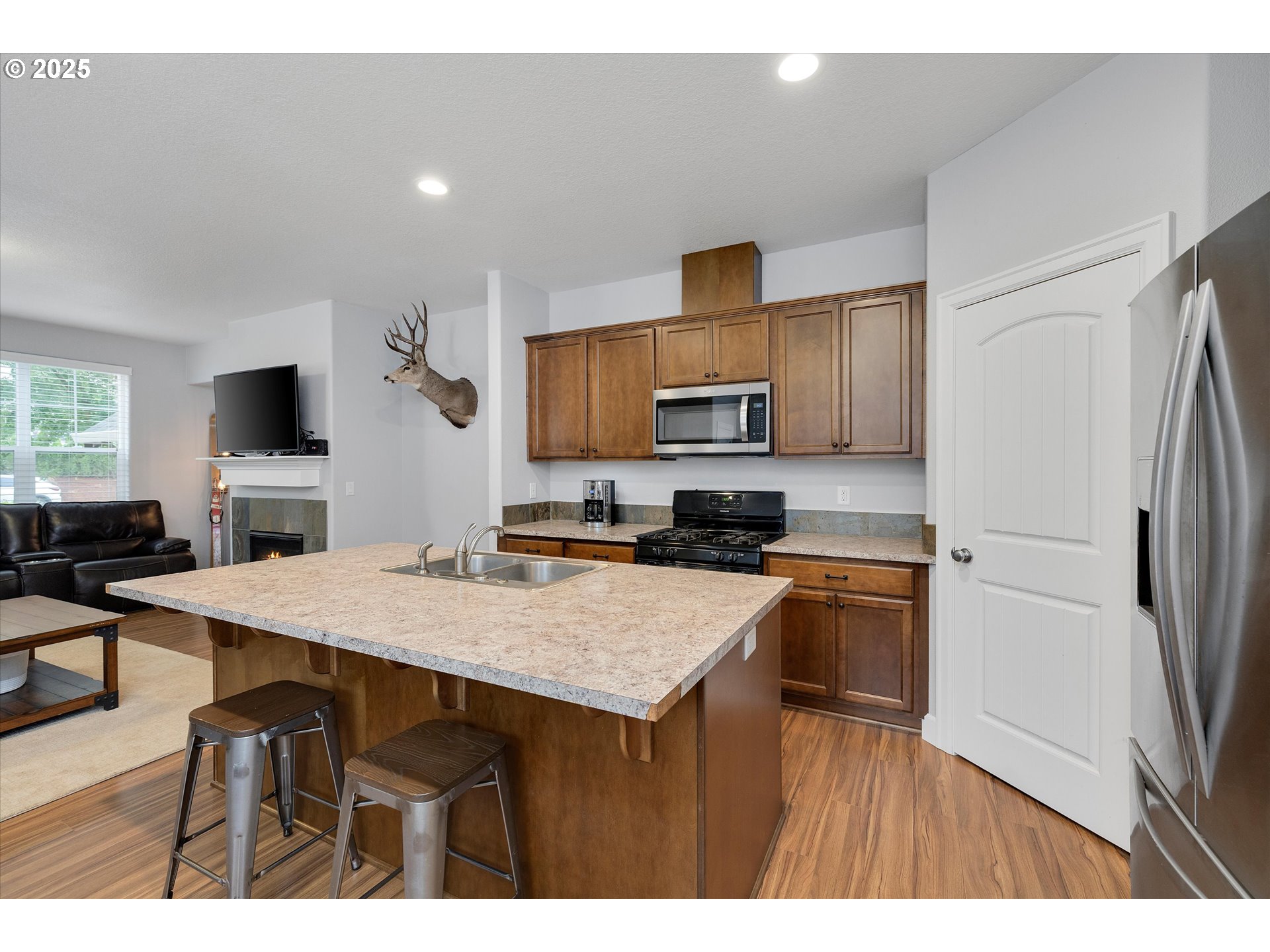 19003 Southeast Village Boulevard Sandy, OR 97055 - Photo 11 of 34 a kitchen with a refrigerator a stove a sink dishwasher and microwave with wooden floor