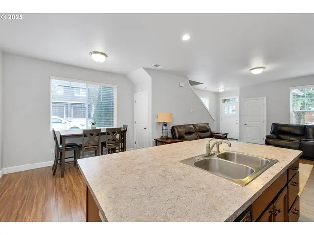 a kitchen with a table chairs and wooden floor