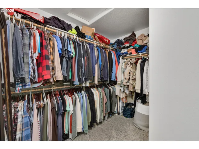 a view of walk in closet with clothes