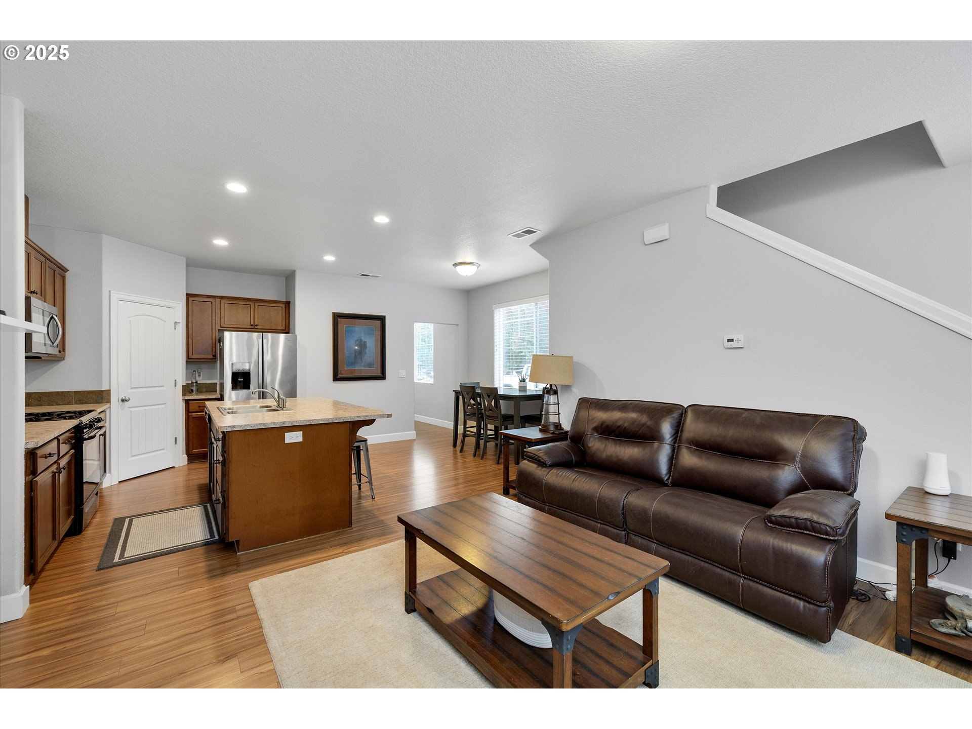 19003 Southeast Village Boulevard Sandy, OR 97055 - Photo 5 of 34 a living room with furniture a kitchen view and a wooden floor