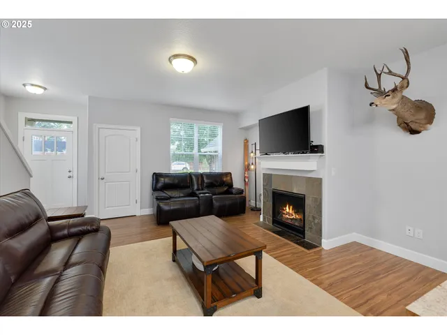 a living room with furniture a flat screen tv and a fireplace