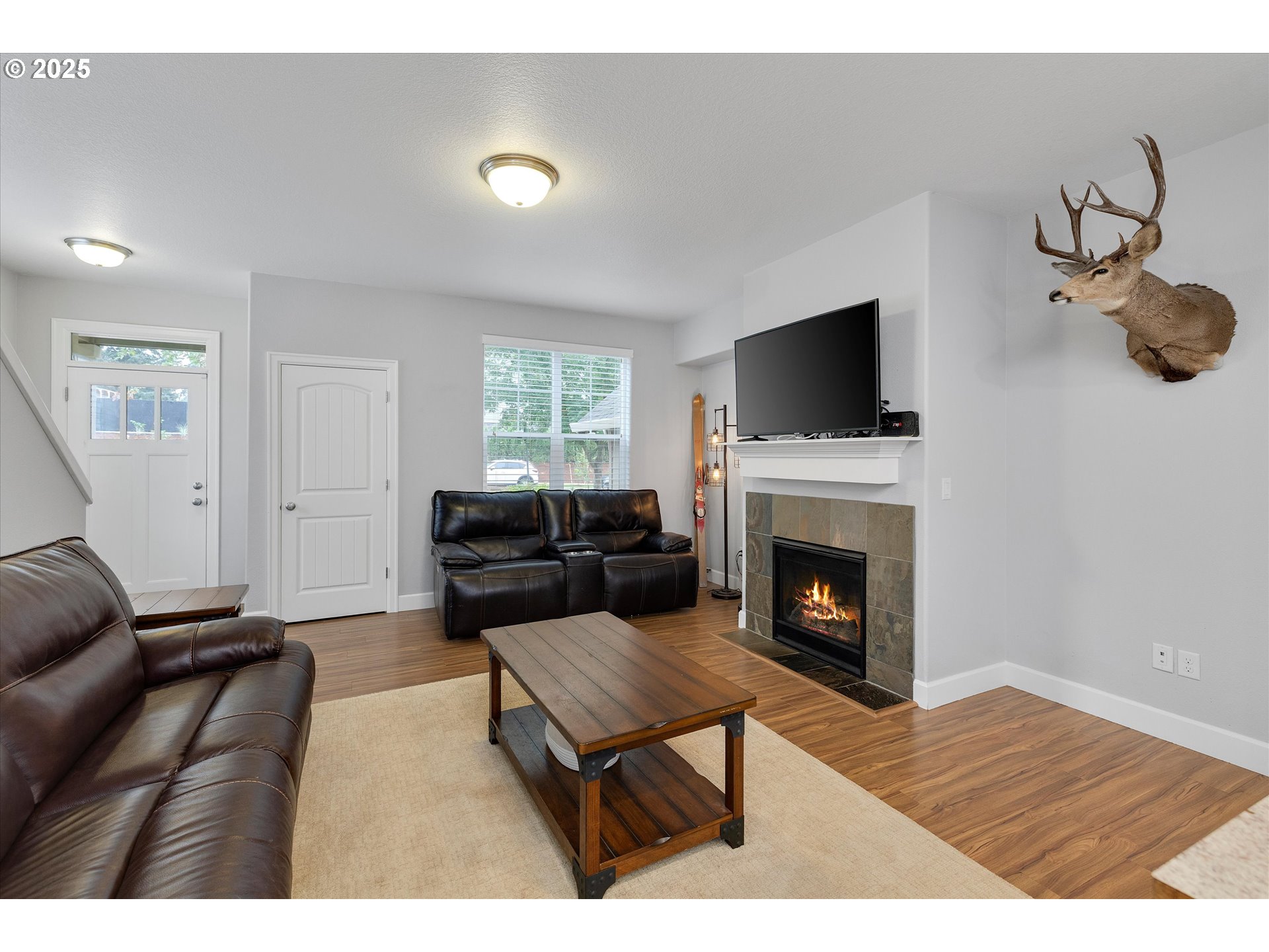 19003 Southeast Village Boulevard Sandy, OR 97055 - Photo 7 of 34 a living room with furniture a flat screen tv and a fireplace