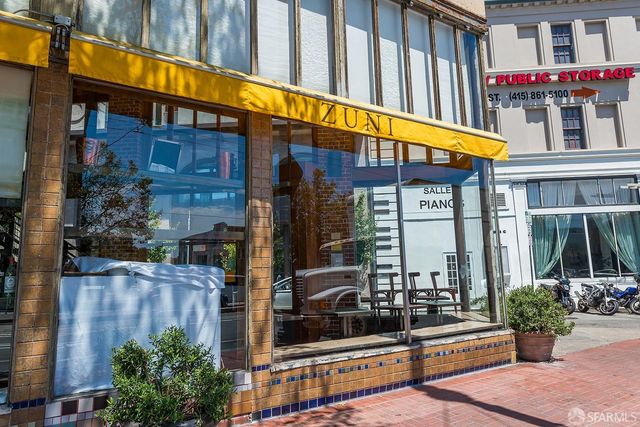 a view of building with glass windows and flower plants