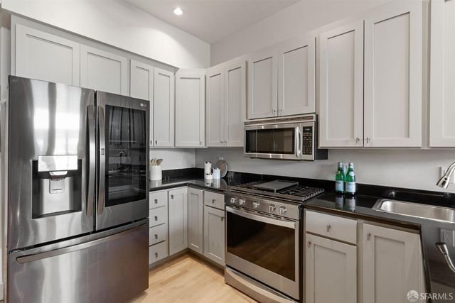 a kitchen with stainless steel appliances white cabinets and a stove