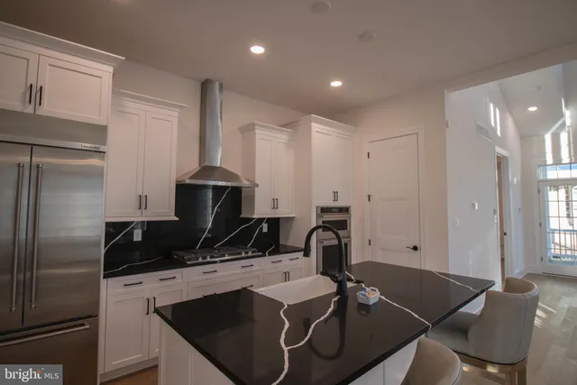 a kitchen with a refrigerator and a stove top oven
