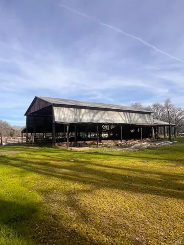 a view of a swimming pool with a lawn chairs under an umbrella