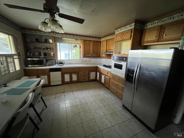 a kitchen with stainless steel appliances granite countertop a sink and a refrigerator