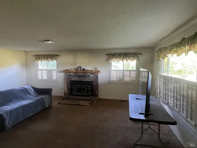 a living room with furniture a fireplace and a large window