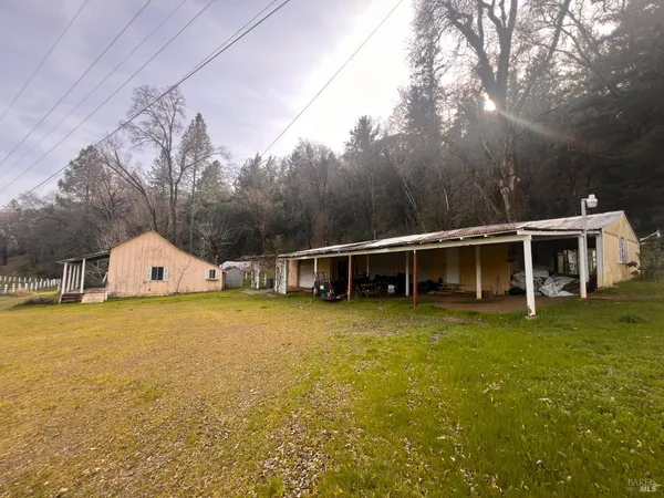 a front view of house with yard and trees in the background