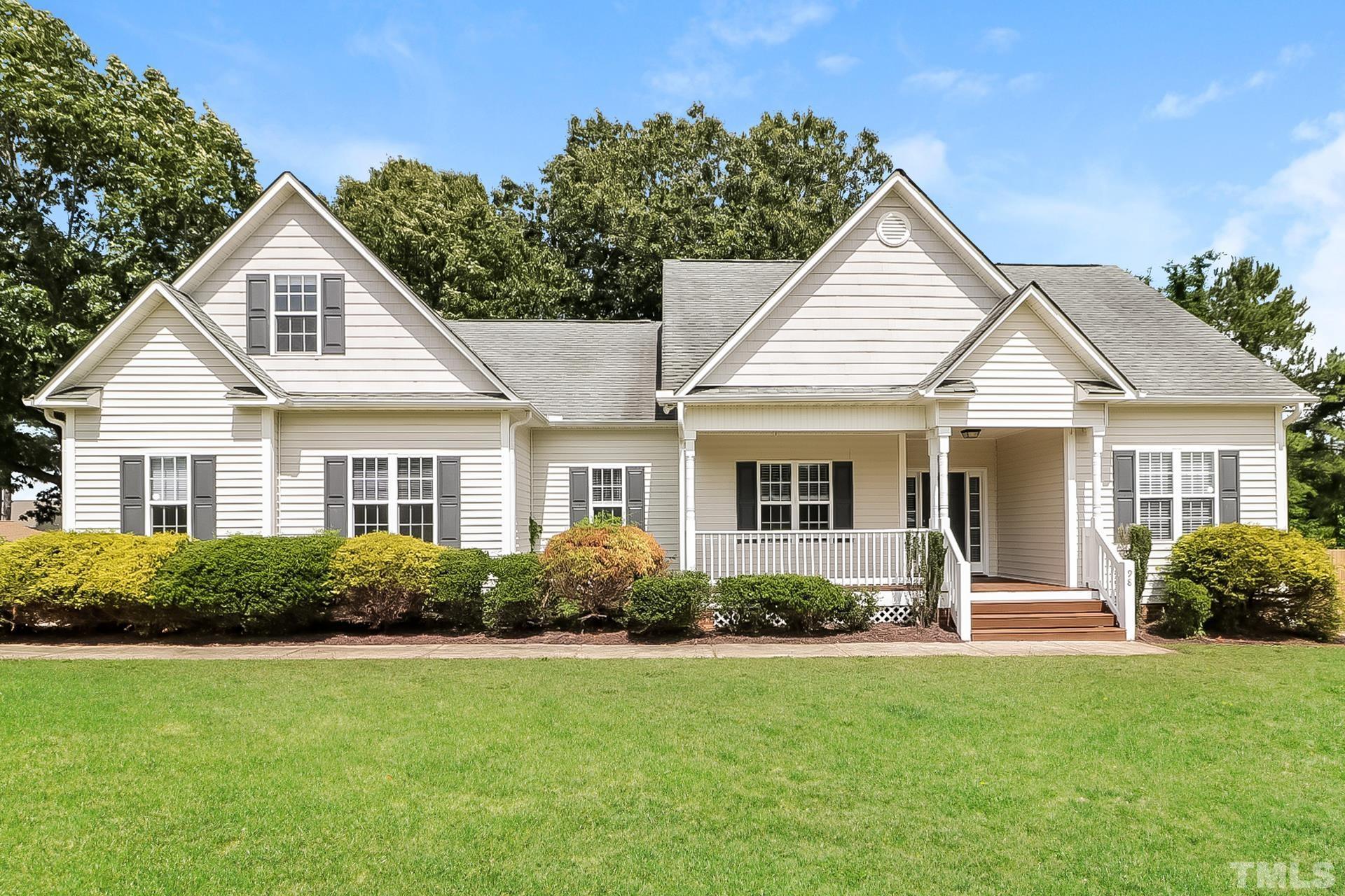 a front view of a house with a yard and potted plants