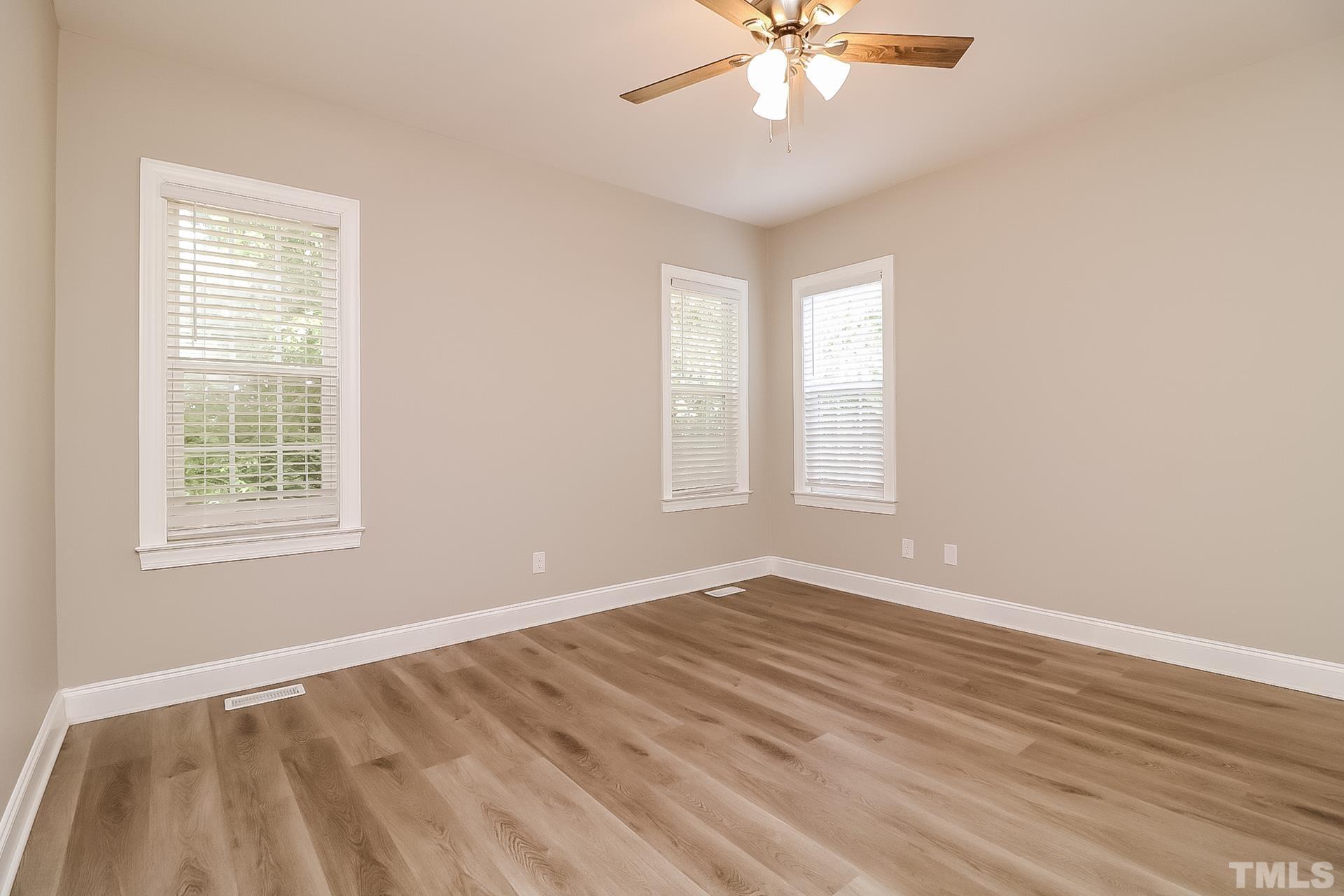 98 Moonlight Drive Garner, NC 27529 - Photo 11 of 17 a view of an empty room with wooden floor and a window