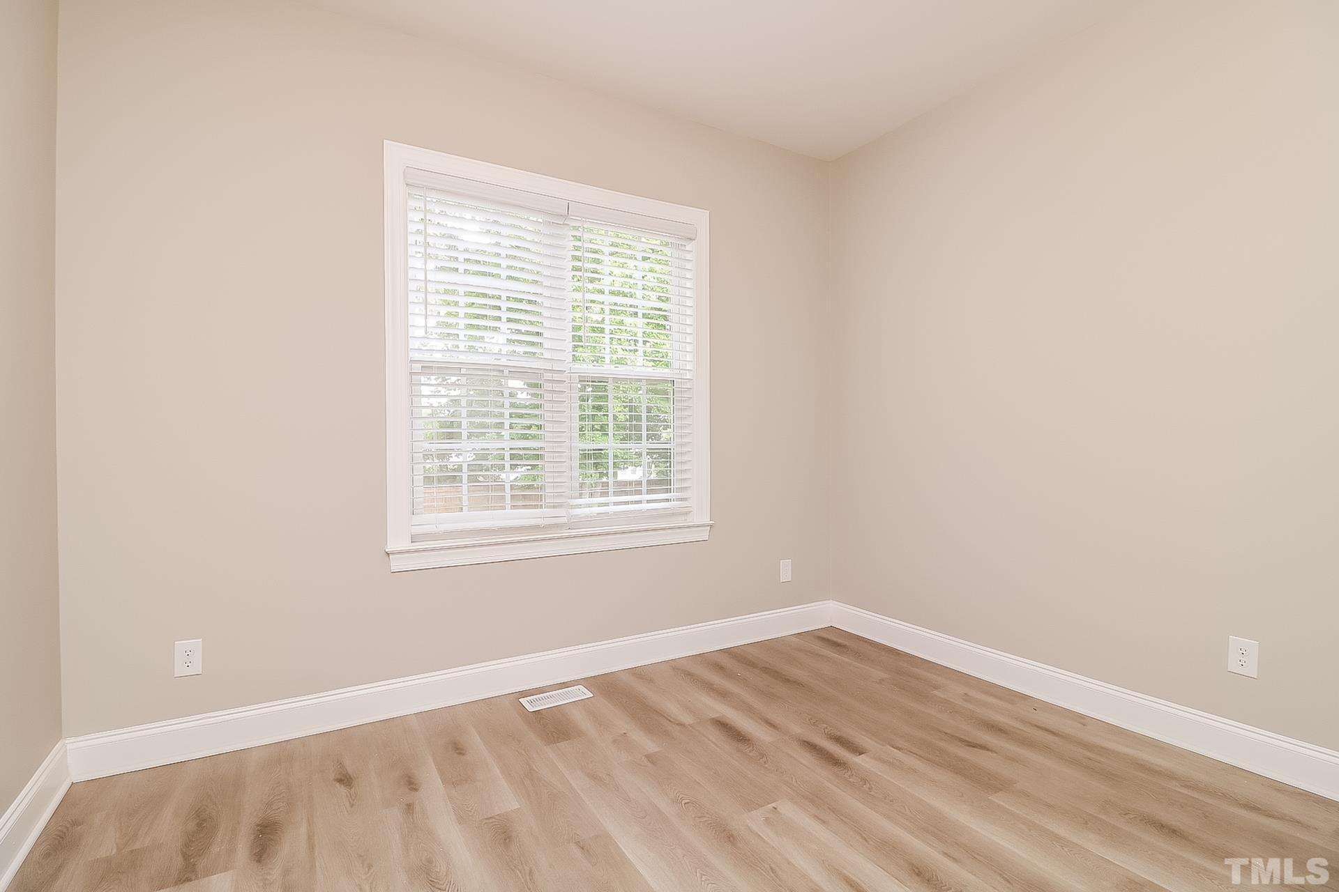 98 Moonlight Drive Garner, NC 27529 - Photo 14 of 17 an empty room with wooden floor and windows