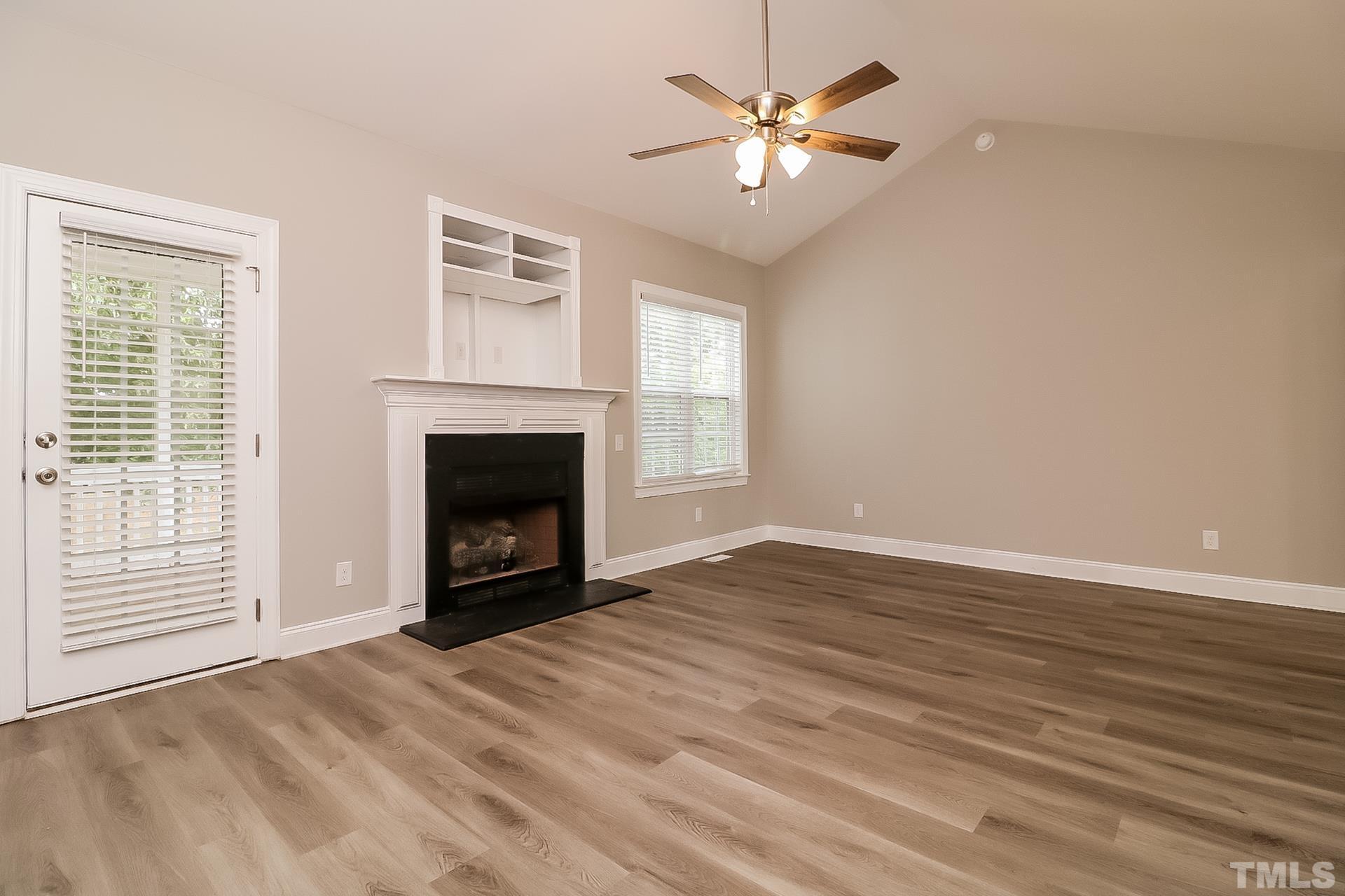 98 Moonlight Drive Garner, NC 27529 - Photo 6 of 17 a view of an empty room with a fireplace and a window