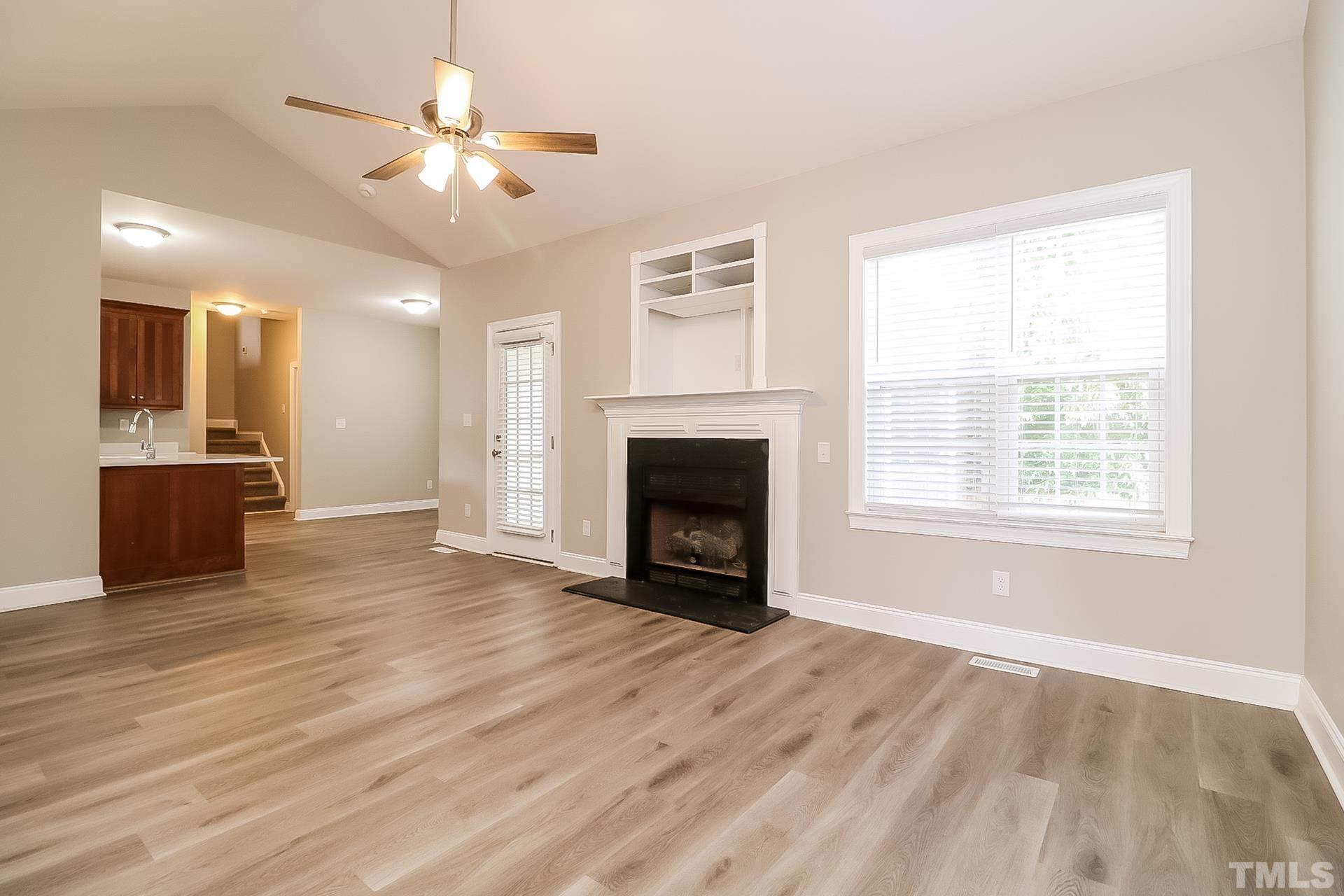 98 Moonlight Drive Garner, NC 27529 - Photo 7 of 17 a view of a livingroom with a fireplace a ceiling fan and wooden floor