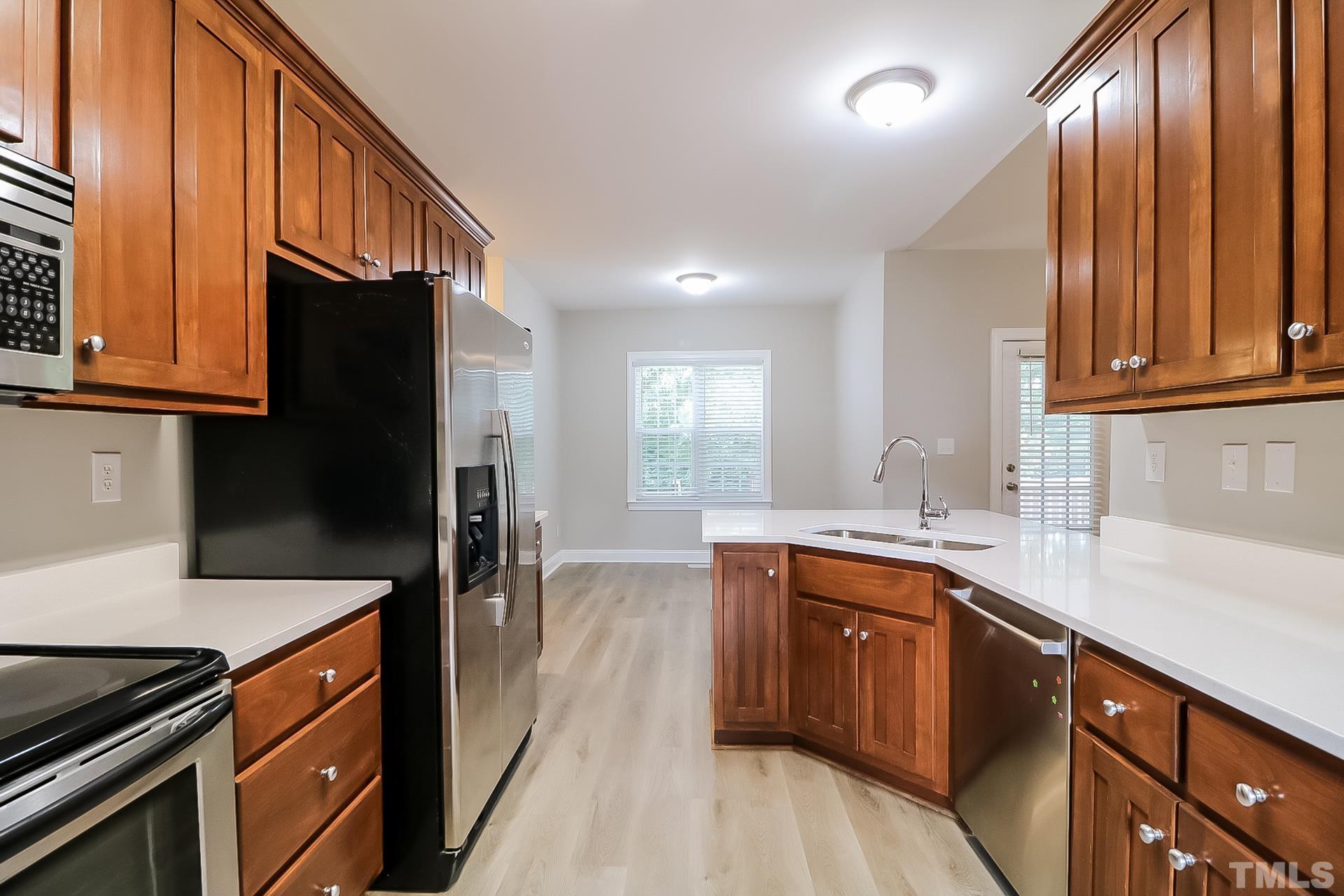 98 Moonlight Drive Garner, NC 27529 - Photo 9 of 17 a kitchen with stainless steel appliances granite countertop a sink a stove and a refrigerator