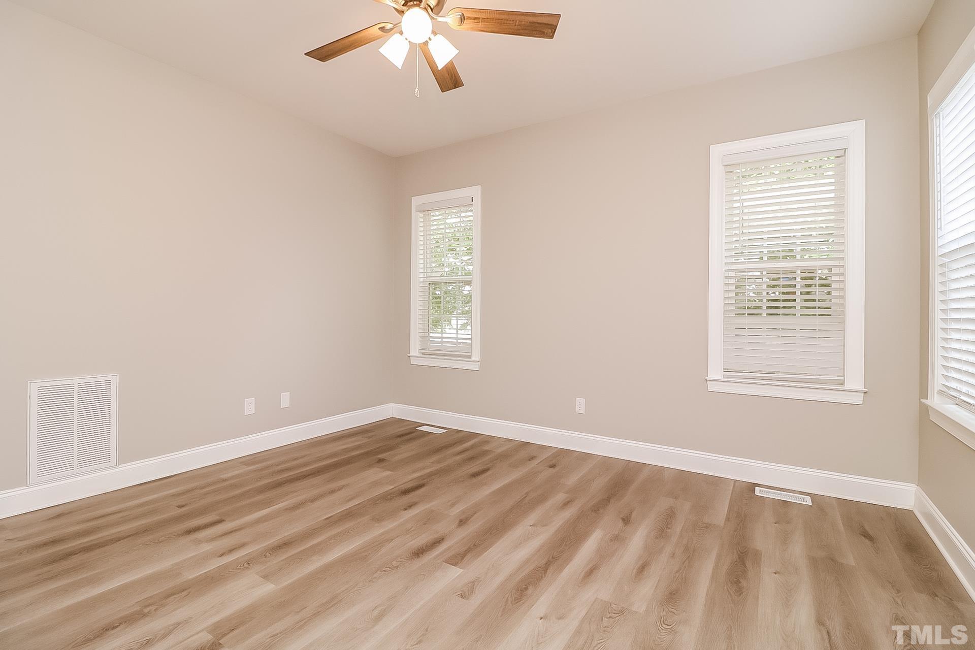 98 Moonlight Drive Garner, NC 27529 - Photo 10 of 17 a view of an empty room with wooden floor and a window