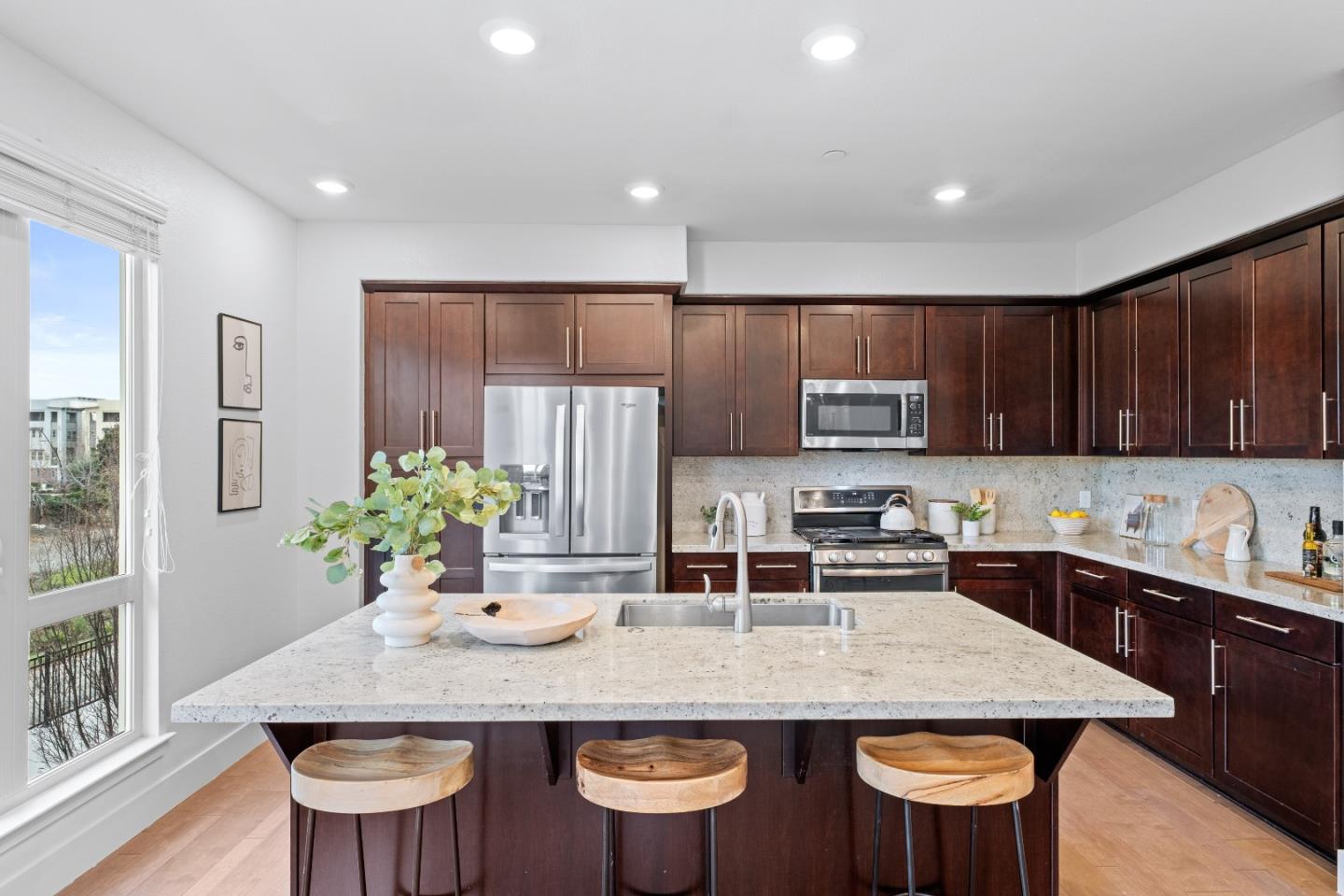 330 Riesling Avenue, Unit 23 Milpitas, CA 95035 - Photo 14 of 51 a kitchen with stainless steel appliances granite countertop a kitchen island a stove a table and chairs