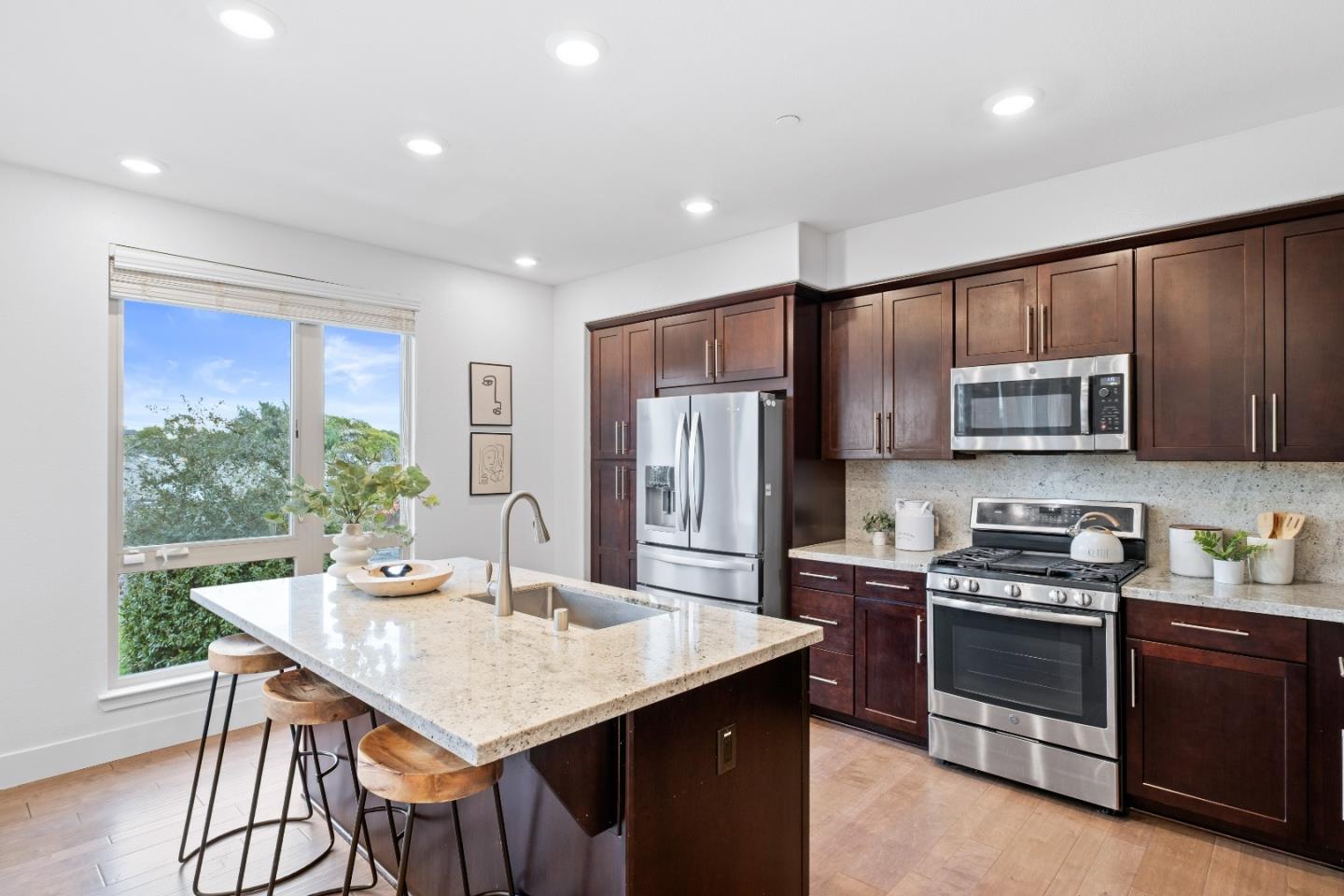 330 Riesling Avenue, Unit 23 Milpitas, CA 95035 - Photo 15 of 51 a kitchen with stainless steel appliances granite countertop a stove a sink a microwave a refrigerator and chairs
