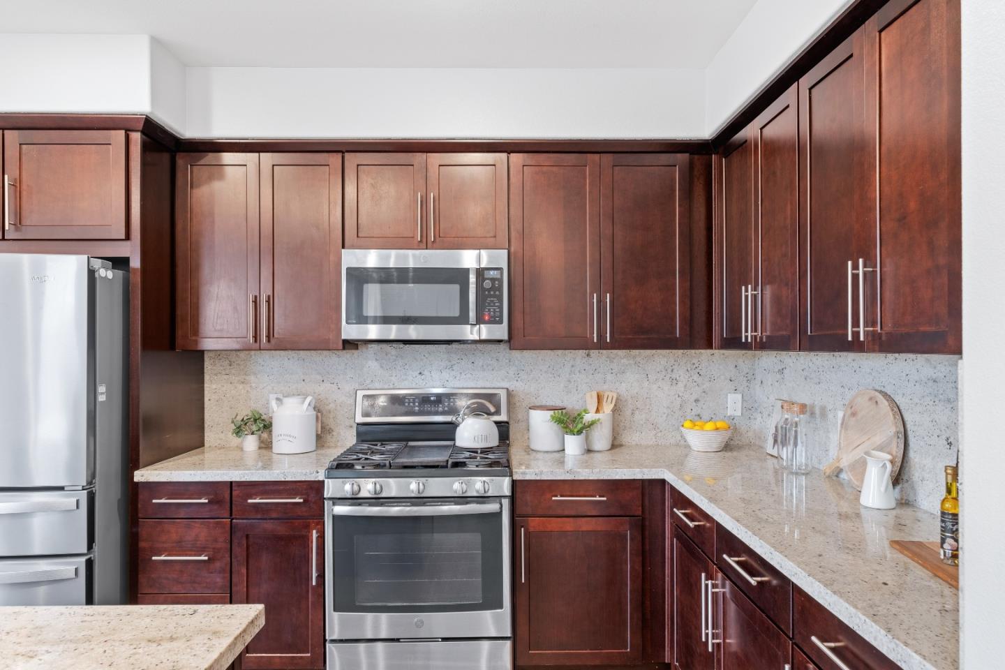 330 Riesling Avenue, Unit 23 Milpitas, CA 95035 - Photo 21 of 51 a kitchen with stainless steel appliances granite countertop wooden cabinets a stove top oven a sink and dishwasher