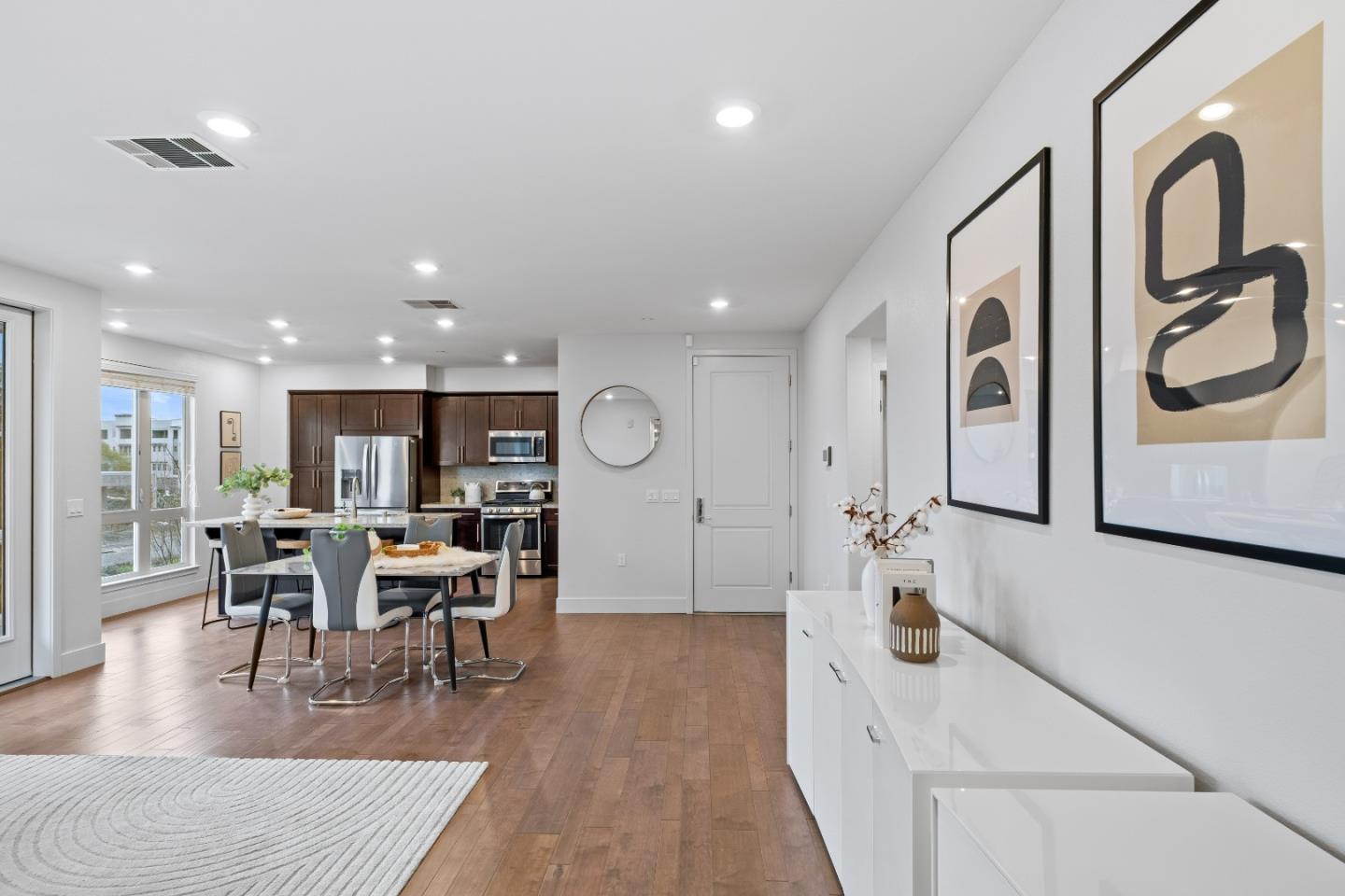 330 Riesling Avenue, Unit 23 Milpitas, CA 95035 - Photo 8 of 51 a large kitchen with stainless steel appliances granite countertop a refrigerator oven a dining table and chairs with wooden floor
