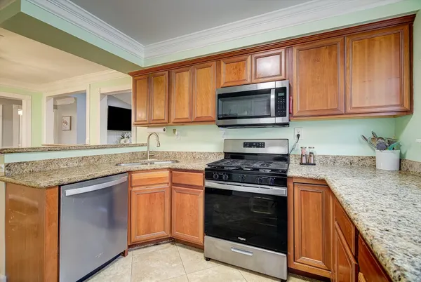 a kitchen with granite countertop a stove top oven microwave and cabinets