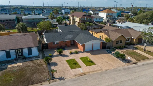 an aerial view of residential houses with outdoor space and parking