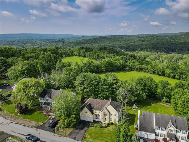 a kitchen with a refrigerator a stove a sink and a dining table with wooden floor