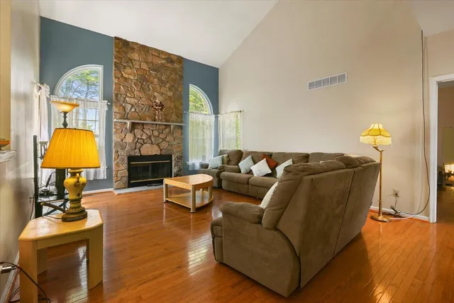 a bathroom with a granite countertop toilet a sink a mirror and a window
