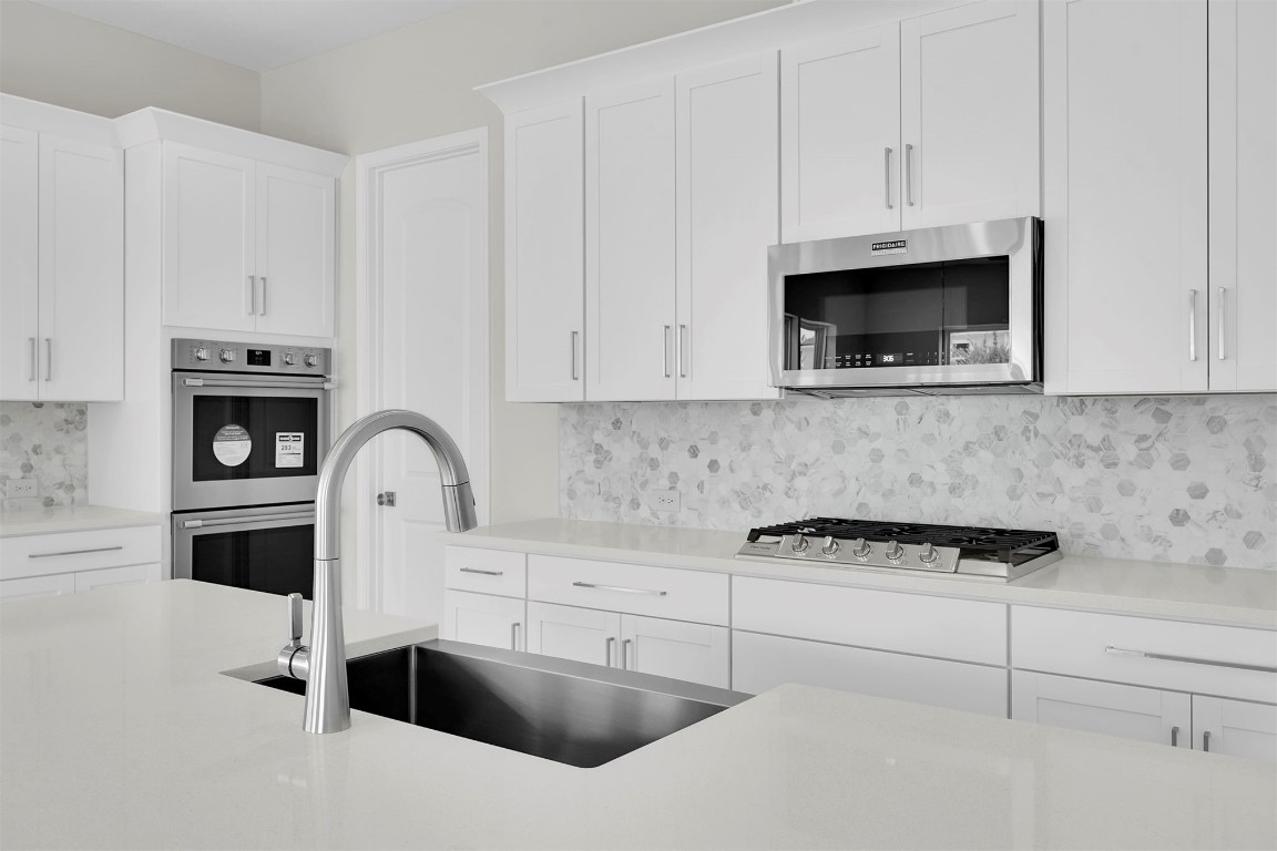 323 Sawgrass Drive Yulee, FL 32097 - Photo 18 of 33 a kitchen with granite countertop white cabinets and stainless steel appliances