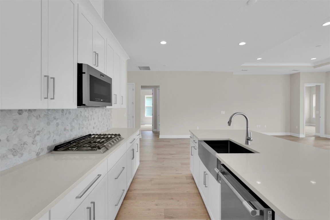 323 Sawgrass Drive Yulee, FL 32097 - Photo 19 of 33 a kitchen with stainless steel appliances kitchen island a white stove top oven and wooden floor