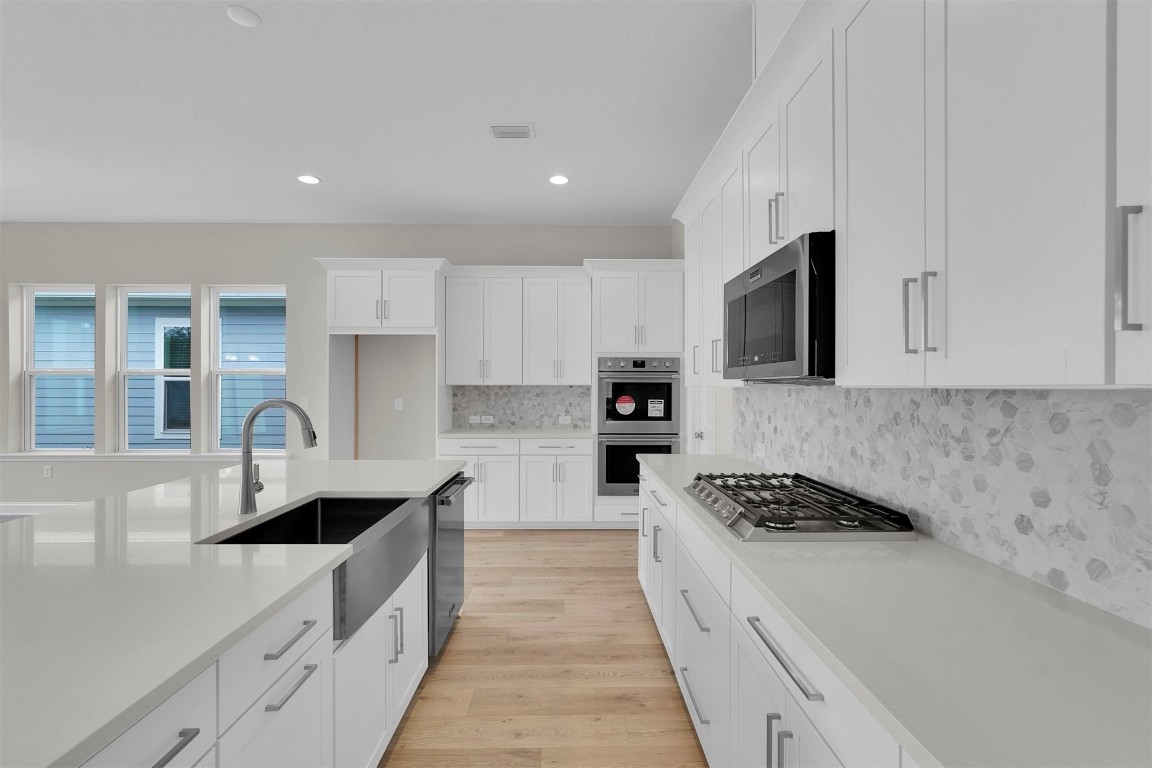 323 Sawgrass Drive Yulee, FL 32097 - Photo 20 of 33 a kitchen with granite countertop a sink stainless steel appliances and cabinets