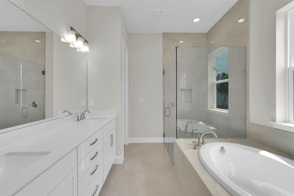 323 Sawgrass Drive Yulee, FL 32097 - Photo 24 of 33 a spacious bathroom with double vanity sinks a large mirror and a bathtub