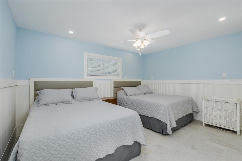14616 Blessing Lane Hudson, FL 34667 - Photo 14 of 29 a bedroom with two large bed and a ceiling fan