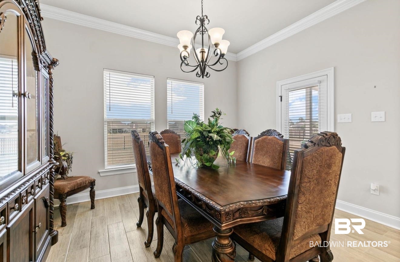 10126 Chipper Lane Foley, AL 36535 - Photo 10 of 30 Dining space with crown molding, light wood finished floors, and a chandelier