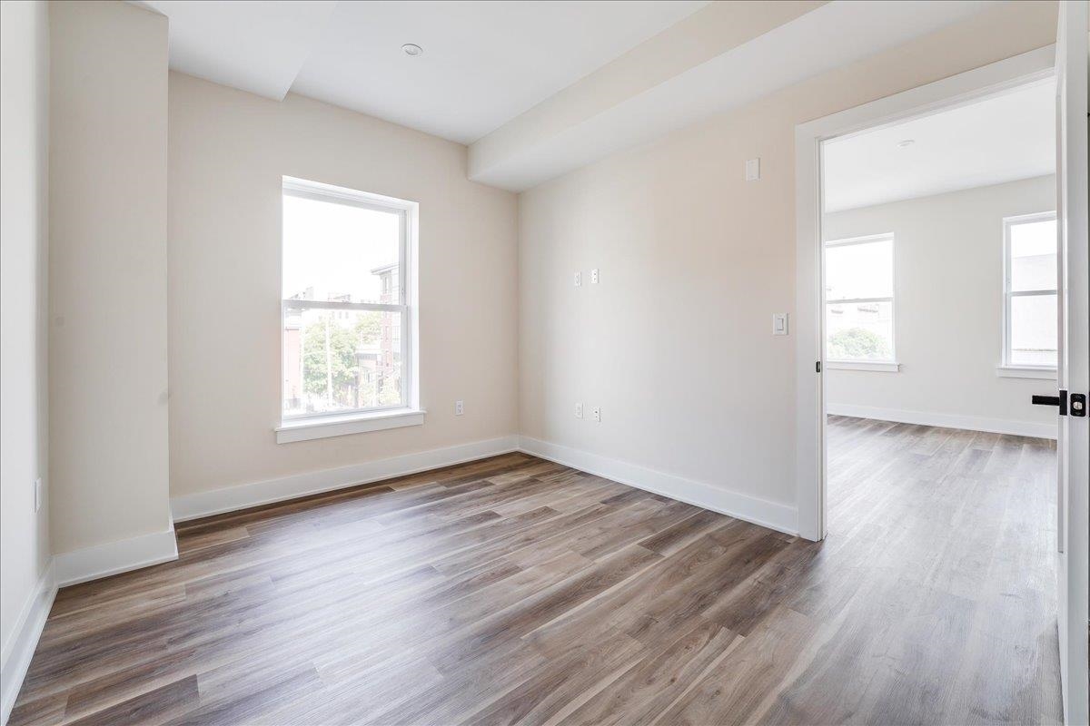 237 Washington Street, Unit 402 Hoboken, NJ 07030 - Photo 11 of 36 an empty room with wooden floor and windows