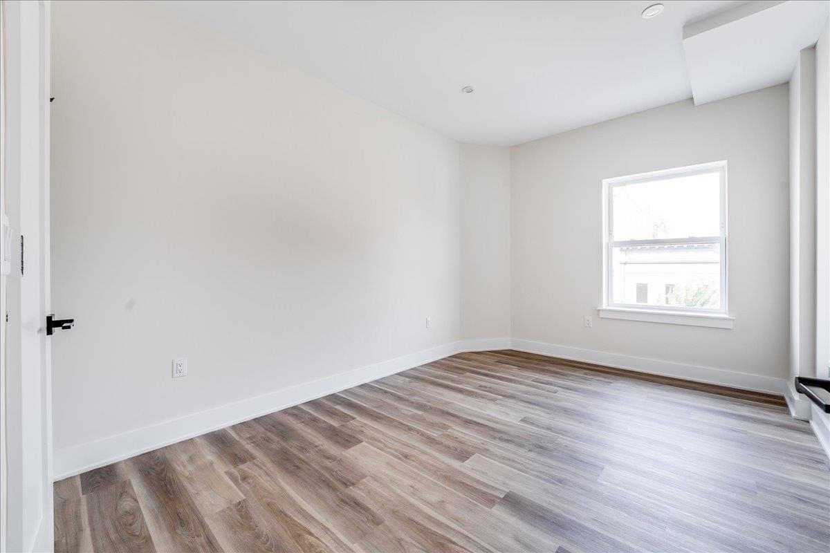 237 Washington Street, Unit 402 Hoboken, NJ 07030 - Photo 12 of 36 an empty room with wooden floor and windows