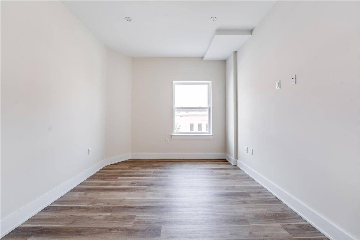 237 Washington Street, Unit 402 Hoboken, NJ 07030 - Photo 13 of 36 an empty room with wooden floor and windows