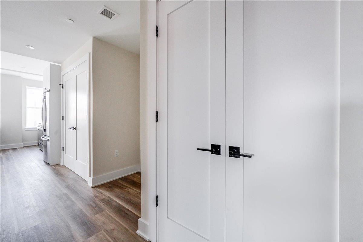 237 Washington Street, Unit 402 Hoboken, NJ 07030 - Photo 15 of 36 a view of a hallway with wooden floor and a bathroom