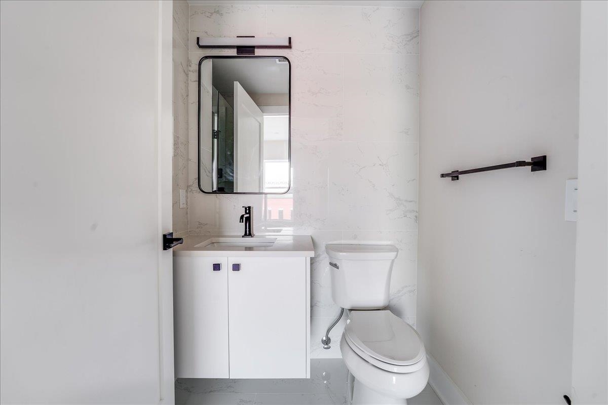 237 Washington Street, Unit 402 Hoboken, NJ 07030 - Photo 19 of 36 a bathroom with a toilet a sink and mirror