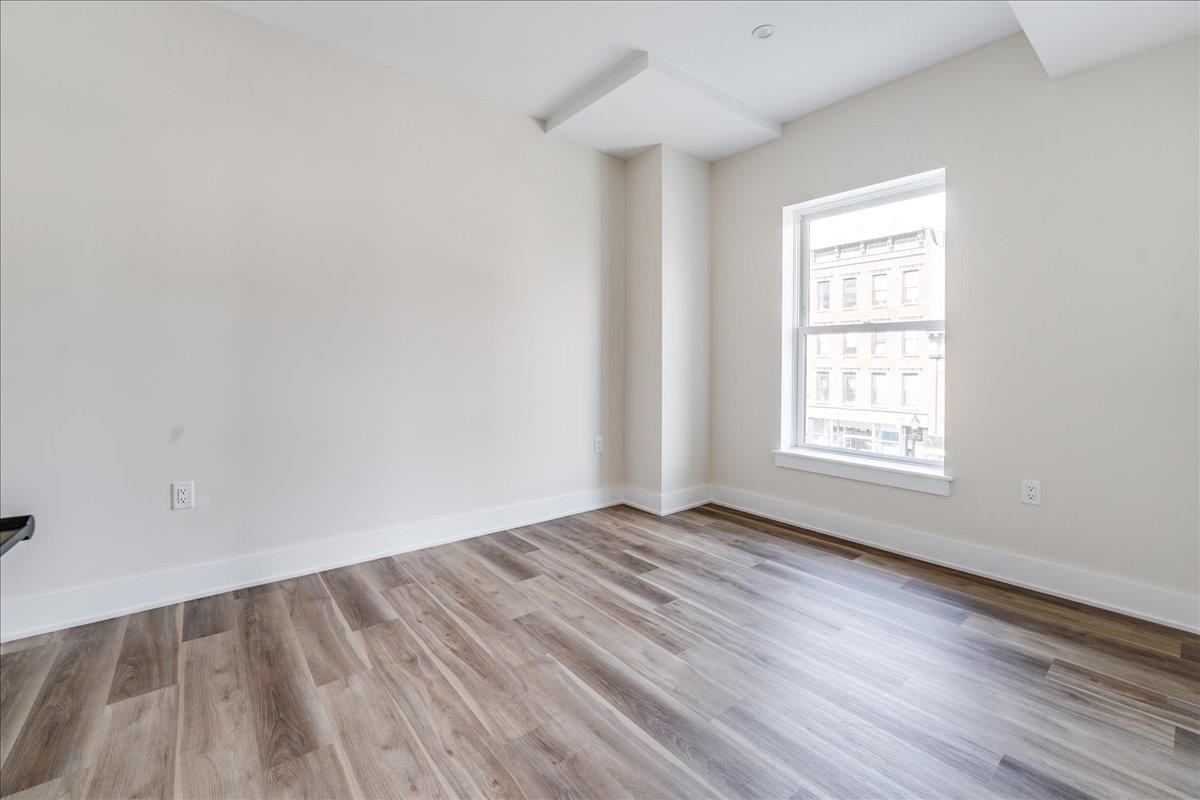 237 Washington Street, Unit 402 Hoboken, NJ 07030 - Photo 10 of 36 an empty room with wooden floor and windows