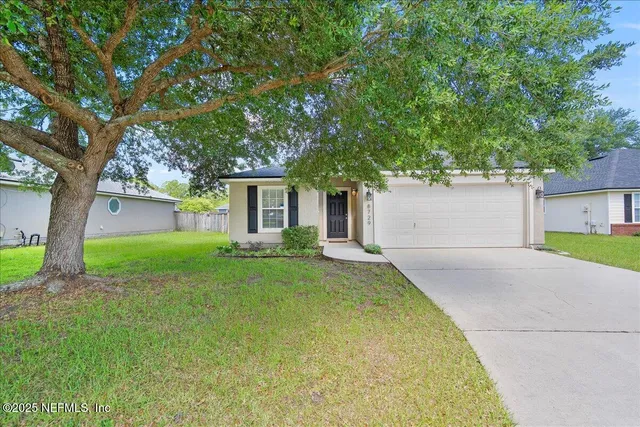front view of a house with a yard and an trees