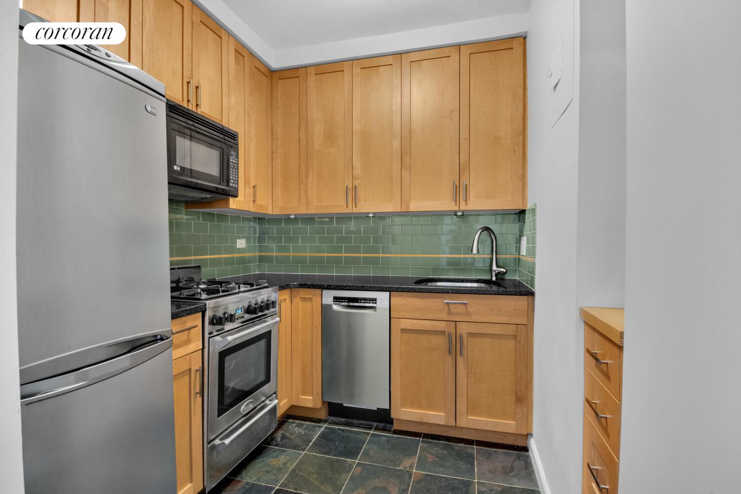 205 3rd Avenue, Unit 12A Manhattan, NY 10003 - Photo 9 of 11 a kitchen with granite countertop white cabinets and white appliances