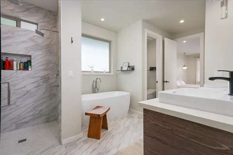 a spacious bathroom with a bathtub shower sink and mirror