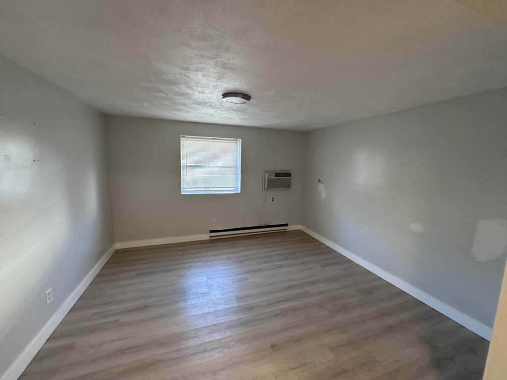 20 Hy-Sil Avenue, Unit 7 Chelsea, MA 02151 - Photo 5 of 9 an empty room with wooden floor and windows