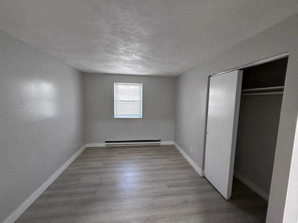 20 Hy-Sil Avenue, Unit 7 Chelsea, MA 02151 - Photo 6 of 9 an empty room with wooden floor and windows