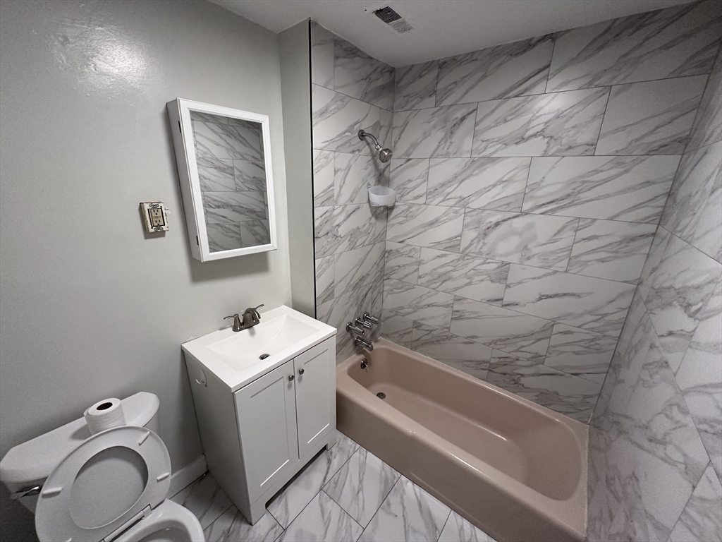 20 Hy-Sil Avenue, Unit 7 Chelsea, MA 02151 - Photo 7 of 9 a bathroom with a granite countertop sink toilet and shower