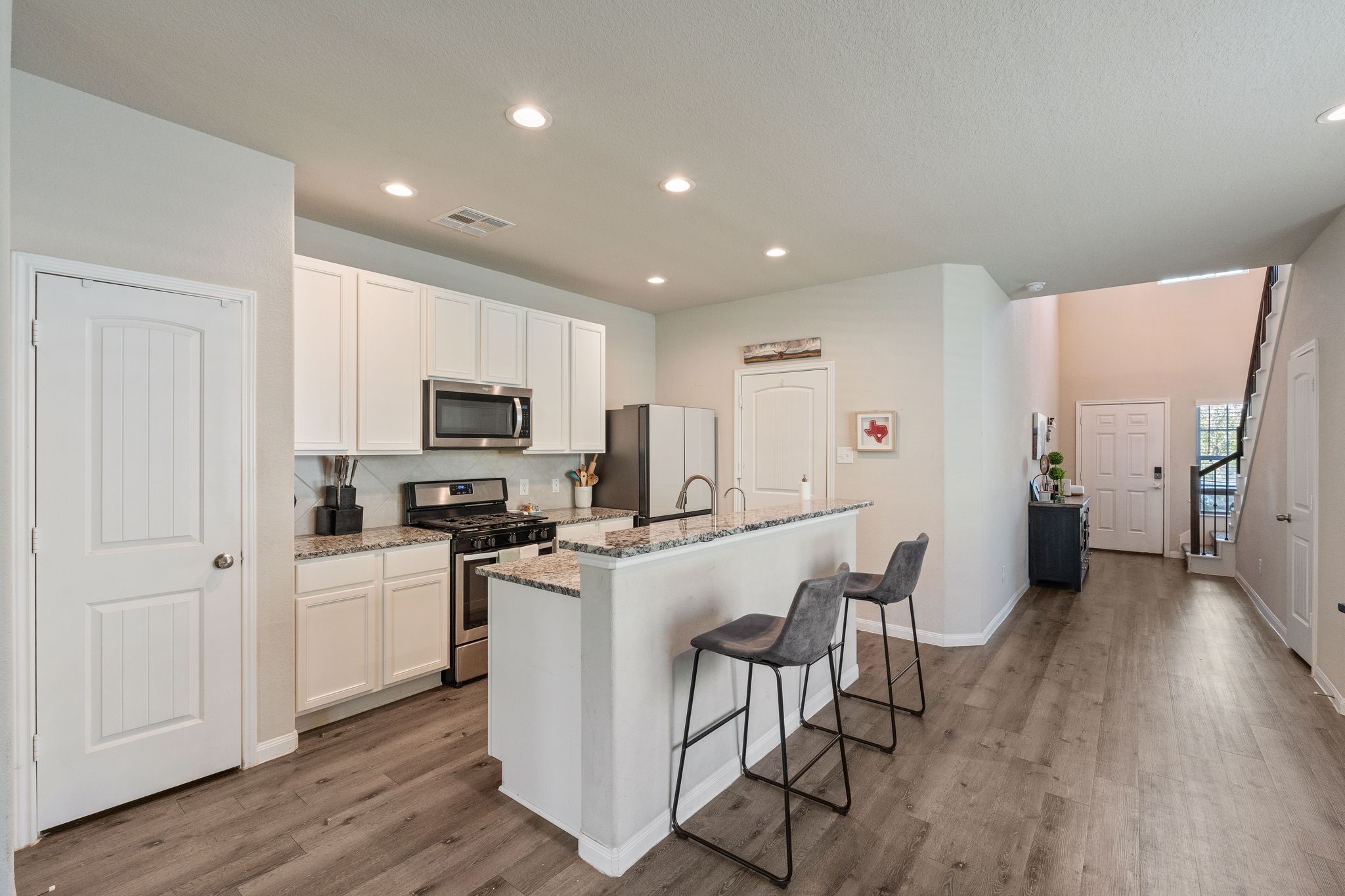 2221 Raider Drive Conroe, TX 77301 - Photo 14 of 42 a kitchen with white cabinets and stainless steel appliances